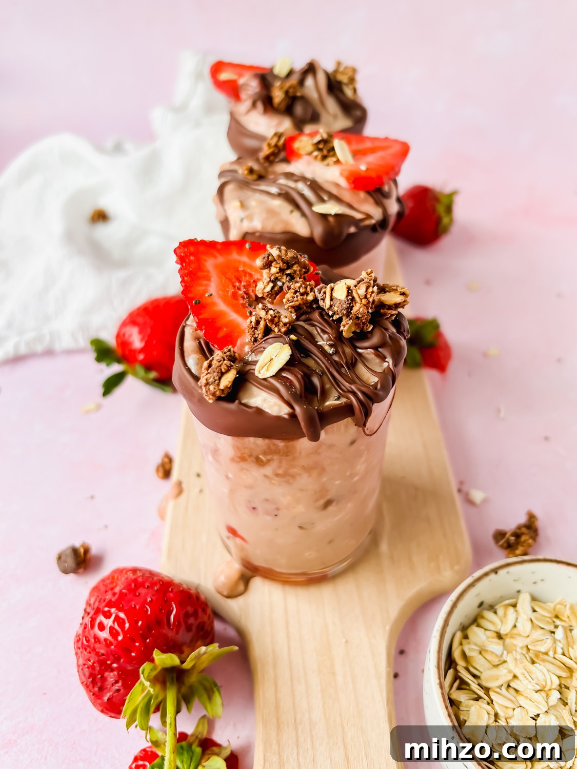 Chocolate-Strawberry Overnight Oats Recipe for Creamy Mornings 8 strawberry chocolate overnight oats garnished with fresh strawberries, chocolate, and oats.