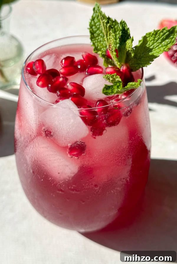 Refreshing Peach Mocktail Recipe for Summer Parties 9 Pomegranate mocktail with pomegranate arils and mint on top.