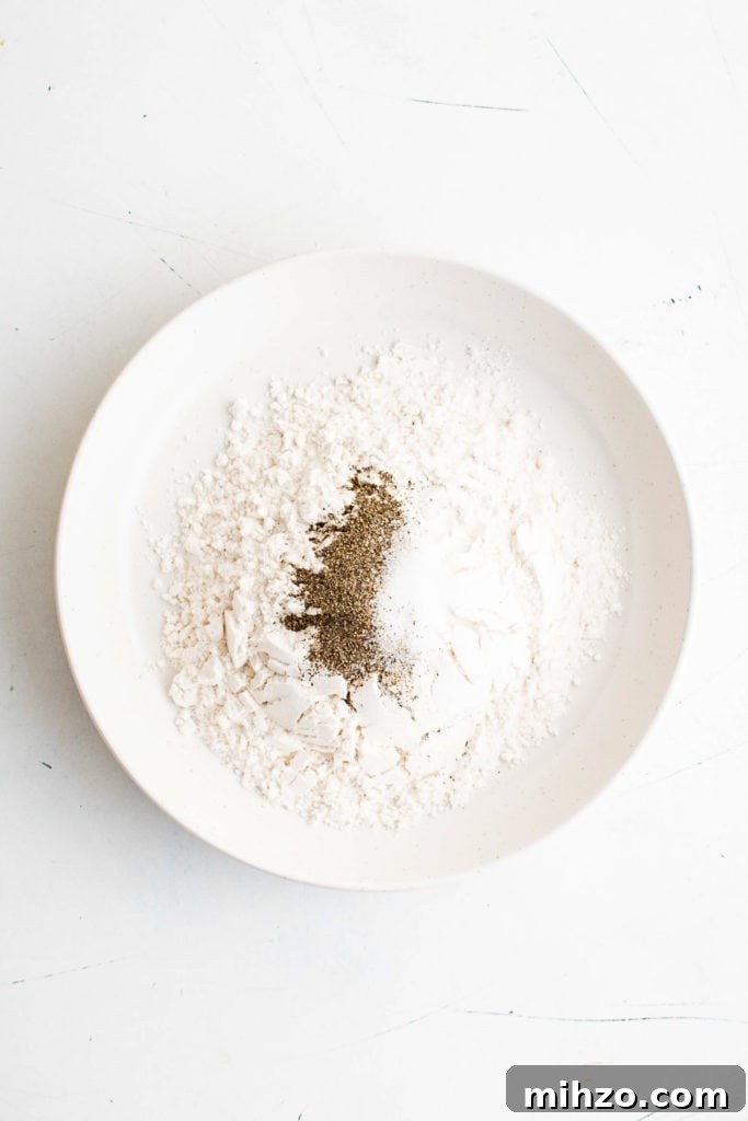 Salt and pepper adding to a dish of flour.