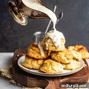 Creamy White Pepper Gravy Recipe for Biscuits and Roast 8 White gravy in a gravy boat being poured on top of a plate of of biscuits.