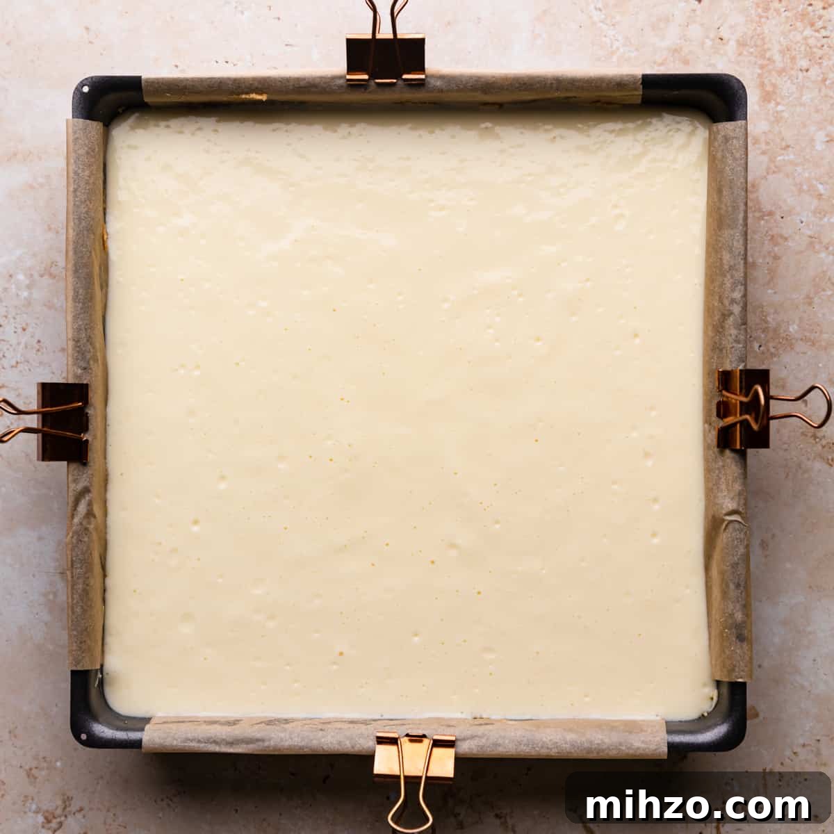 cheesecake batter inside of the lined baking pan.