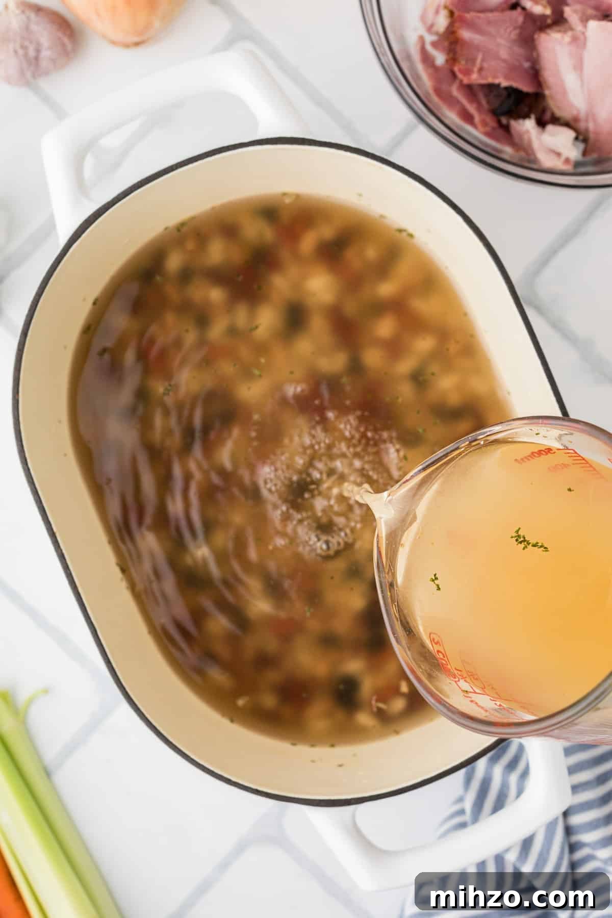 Pouring broth into a large pot.