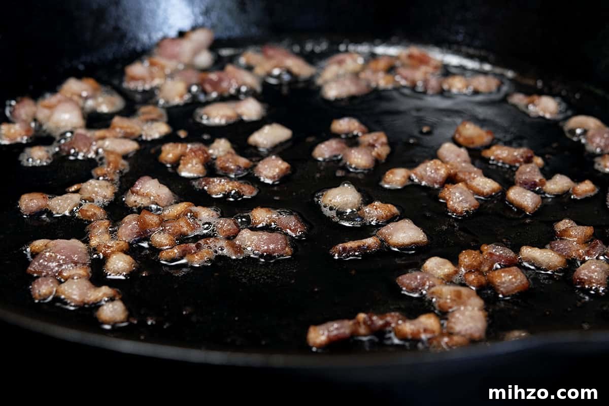 Authentic Cajun Maque Choux Recipe with Sweet Corn and Bacon 5 crisping diced bacon in skillet
