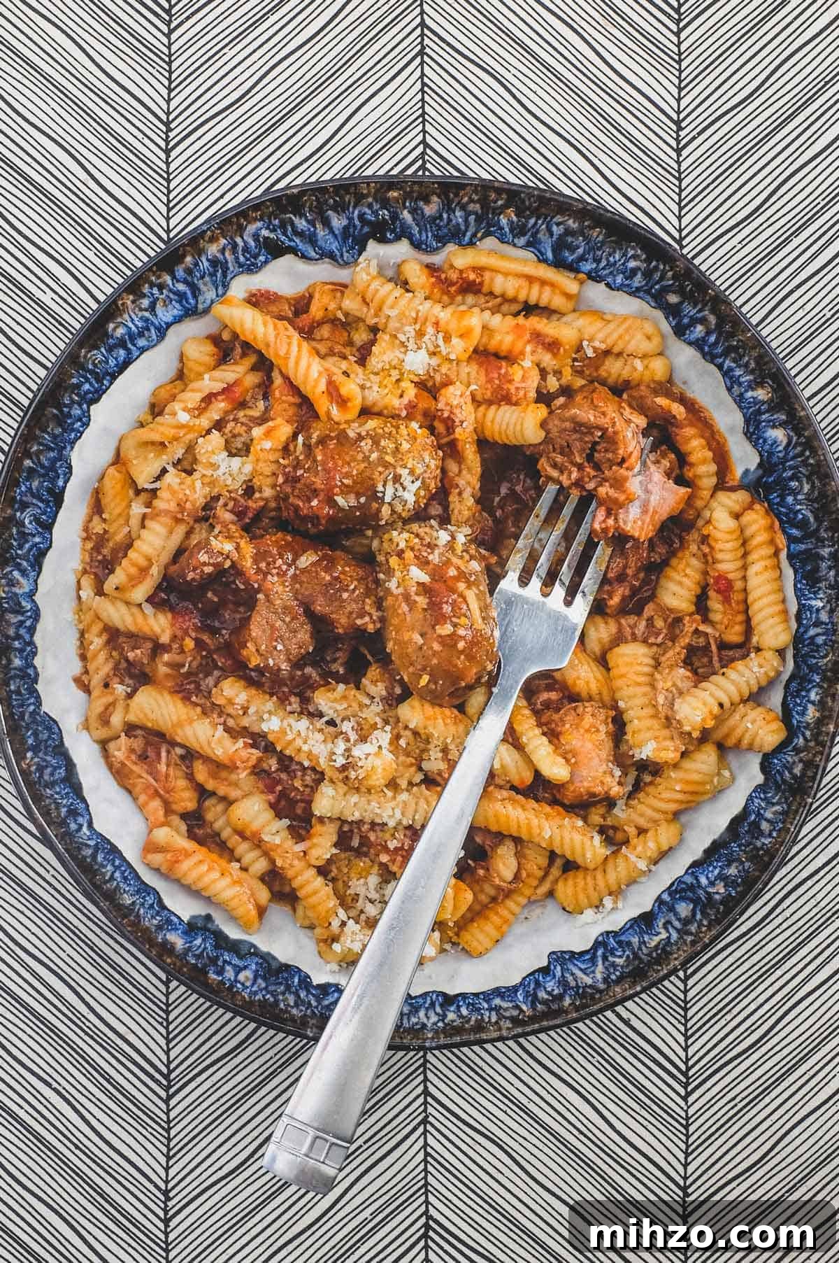 Cavatelli with Pork Ragù | cookeatworld.com A bowl of cavatelli pasta with pork ragù with a fork