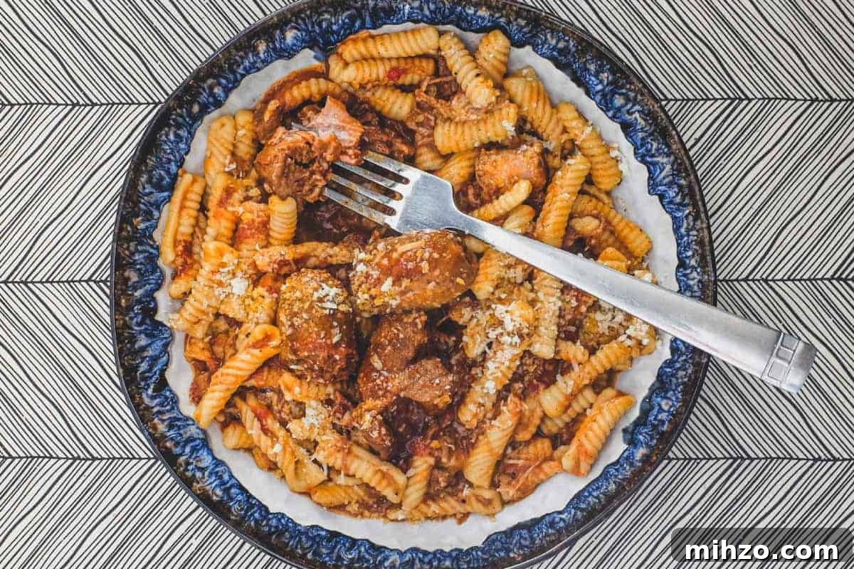 Cavatelli with Slow-Simmered Pork RagùRecipe 2 A bowl of cavatelli pasta with pork ragù with a fork