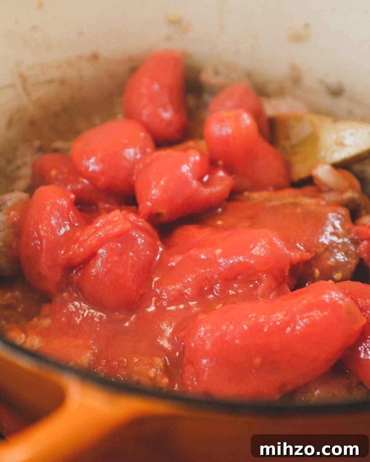 Cavatelli with Pork Ragù | cookeatworld.com Plum tomatoes being added to a pork ragu sauce