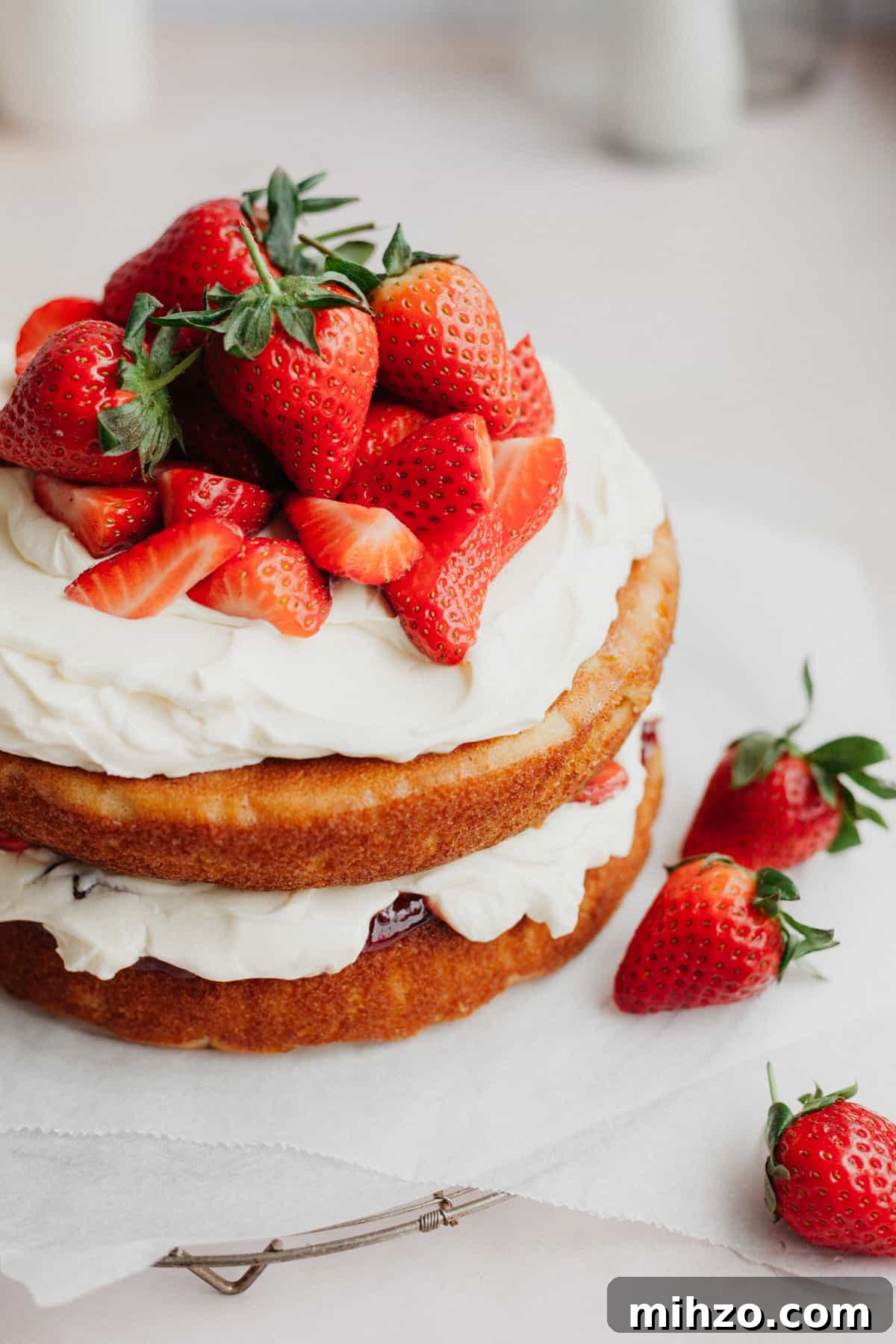 A strawberry filled cake on parchment paper