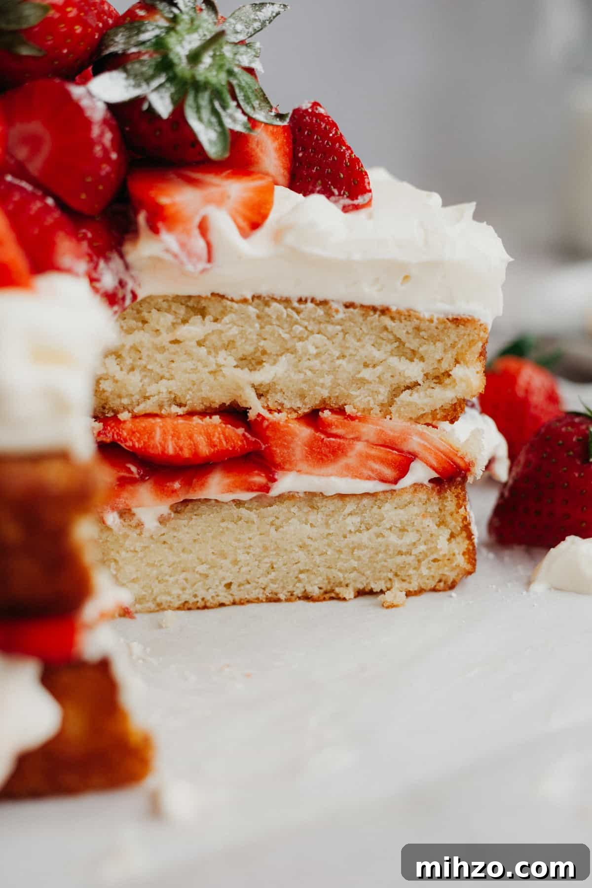 A close up of a strawberry filled cake that has had several slices taken out