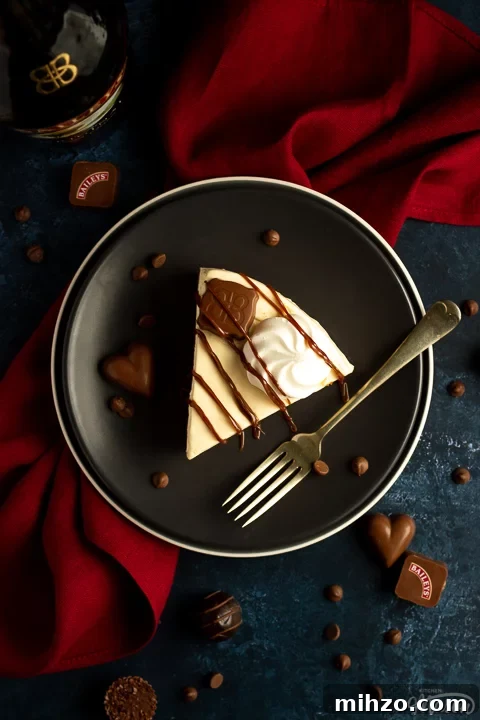No-Bake Baileys Cheesecake Recipe: Creamy Irish Cream Dessert 6 A slice of no bake Baileys cheesecake on a plate with a fork over a red napkin