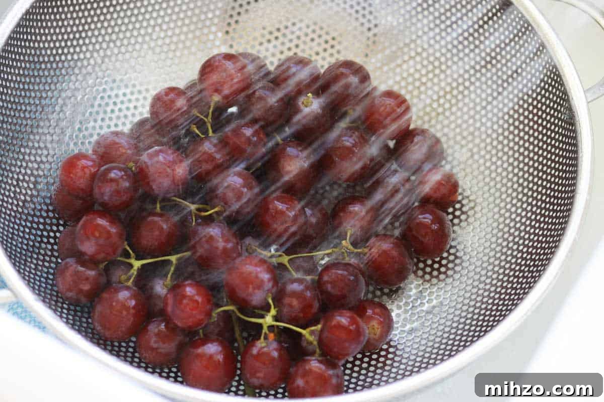 Wash Fruit with Vinegar: DIY Produce Cleaning Spray 4 grapes being washed in a strainer