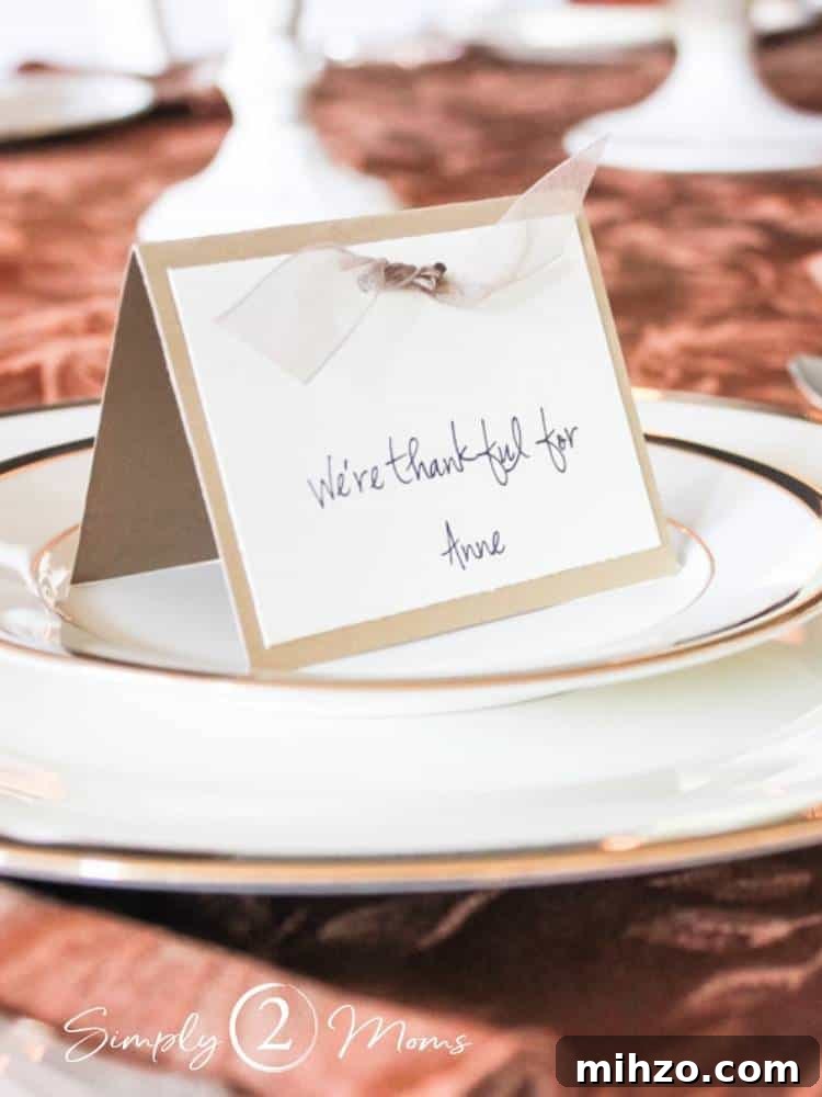 13+ Creative Ways to Make Your Thanksgiving Memorable 8 folded place card with ribbon embellishment at top on stack of china plates on Thankgiving table