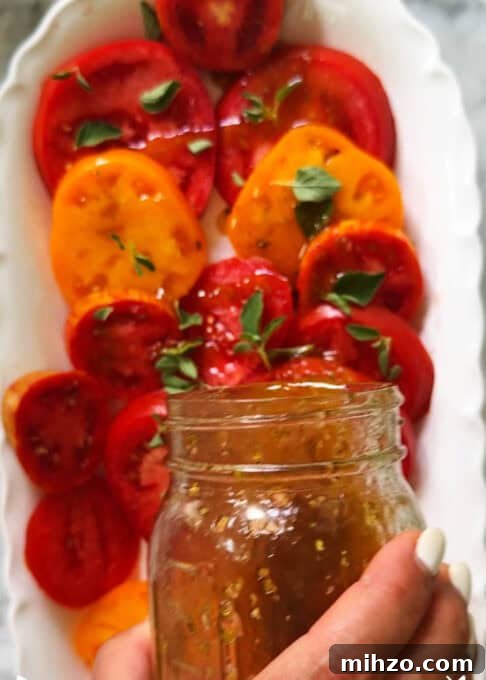 Dressing is poured over the heirloom tomato salad 