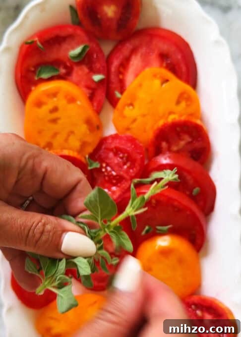 Fresh oregano placed on the heirloom tomato salad