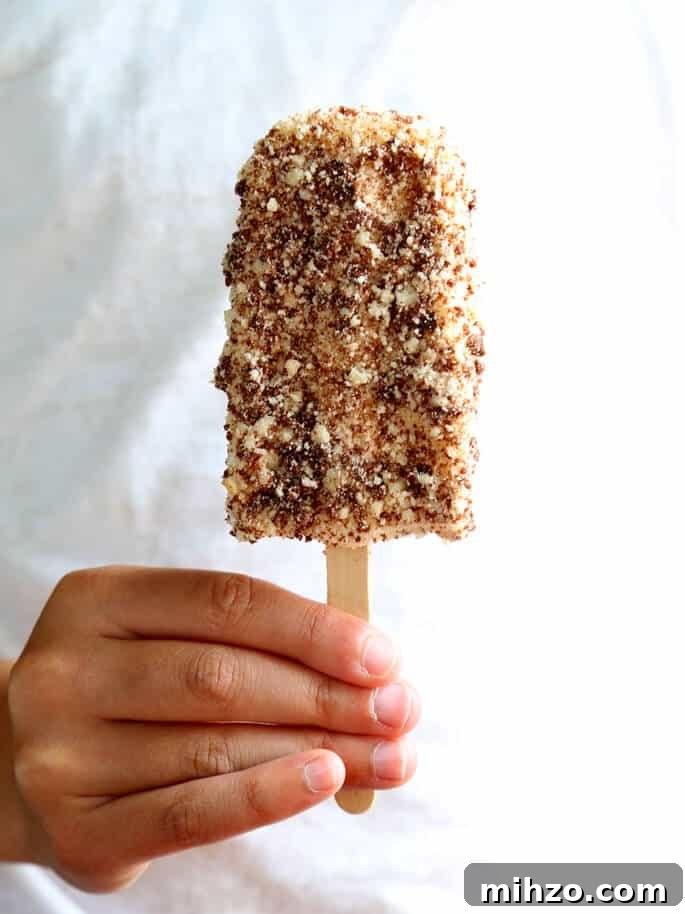 Gluten-Free Chocolate Éclair Ice Cream Bars (Good Humor Copycat) 2 Person holing chocolate eclair ice cream pop on white background
