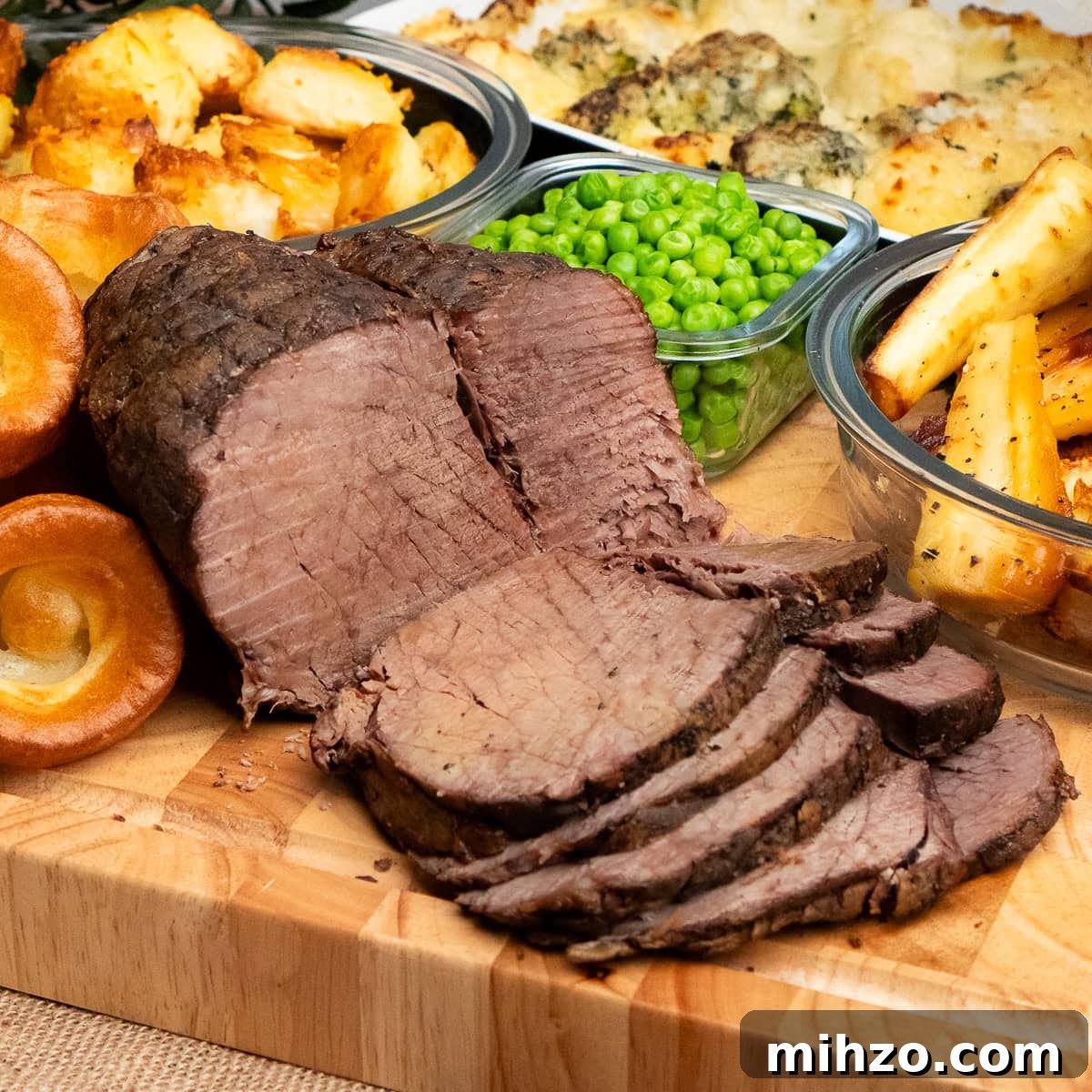 Slow cooker beef joint cut into thin slices. Served amongst honey roast parsnips, yorkshire puddings, peas, cauliflower and broccoli cheese and roast potatoes