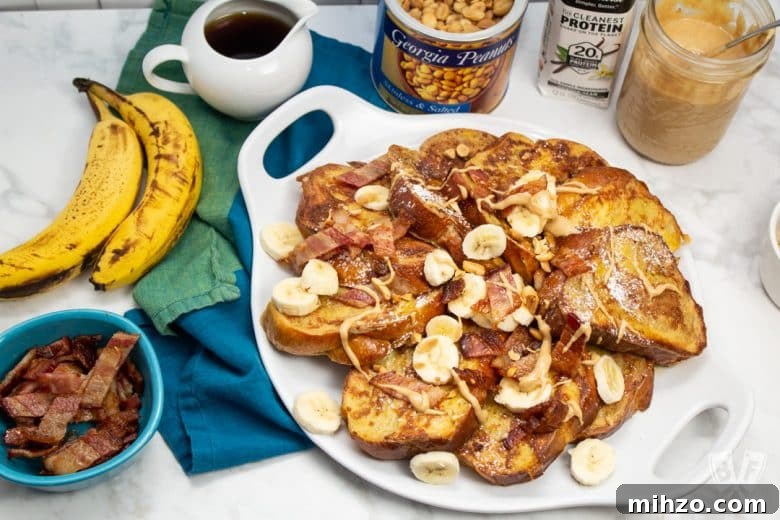 Elvis-Inspired Banana-Peanut Butter Challah French Toast 2 Overhead view of French toast with bananas, bacon, peanut butter, and topping alongside.