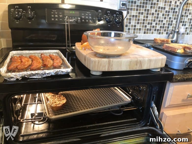 Elvis-Inspired Banana-Peanut Butter Challah French Toast 7 An oven and a griddle in the process of cooking bacon and French toast.