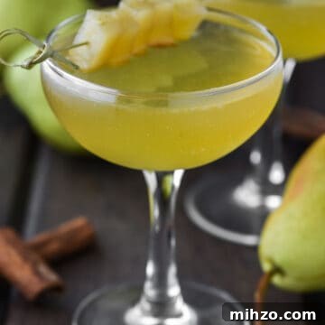 Two coupe glasses of pear martinis.