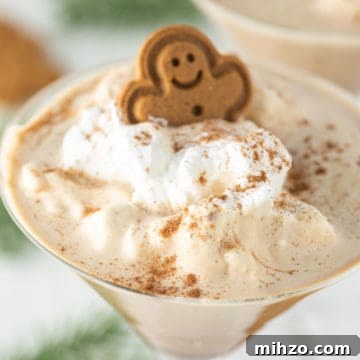 Gingerbread martini with whipped cream and gingerbread man on top.