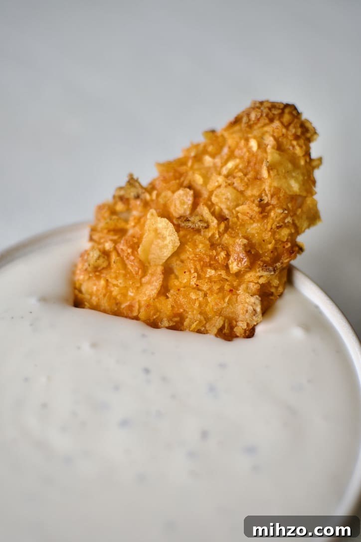 Crunchy Dorito-Crusted Baked Chicken Recipe 2 Dorito Chicken being dipped in ranch dressing.