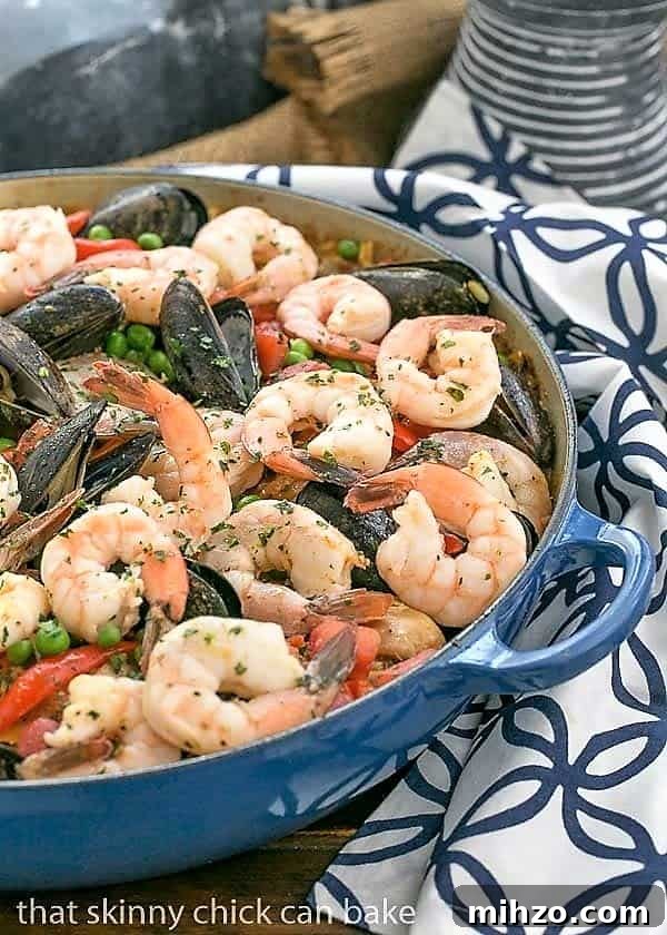 Julia Child’s American-Style Paella Recipe 2 Julia Child's Paella a l'Americaine in a cast iron paella dish on a blue and white napkin