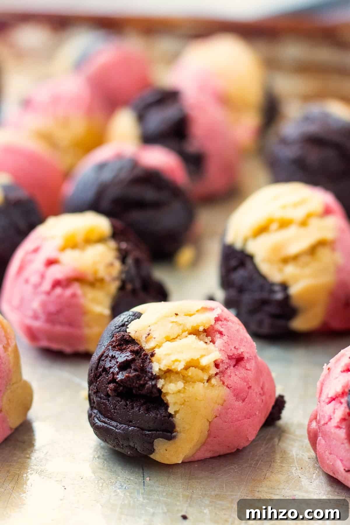 Authentic Neapolitan Cookies Recipe: Classic Layered Biscuits 9 Raw neapolitan cookie dough balls on metal baking sheet.