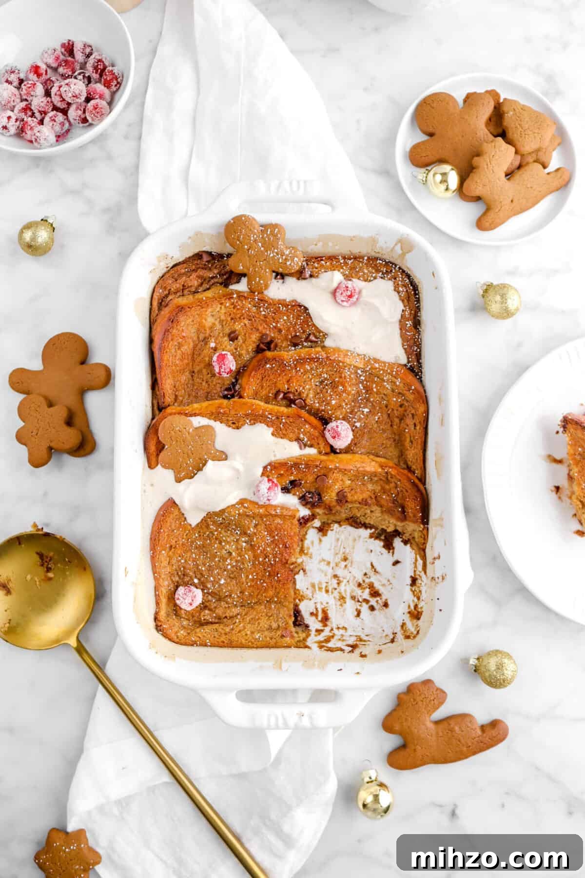 Overnight Gingerbread Chocolate Chip French Toast Bake 18 slice taken from casserole on white napkin with cookies and gold ornaments around