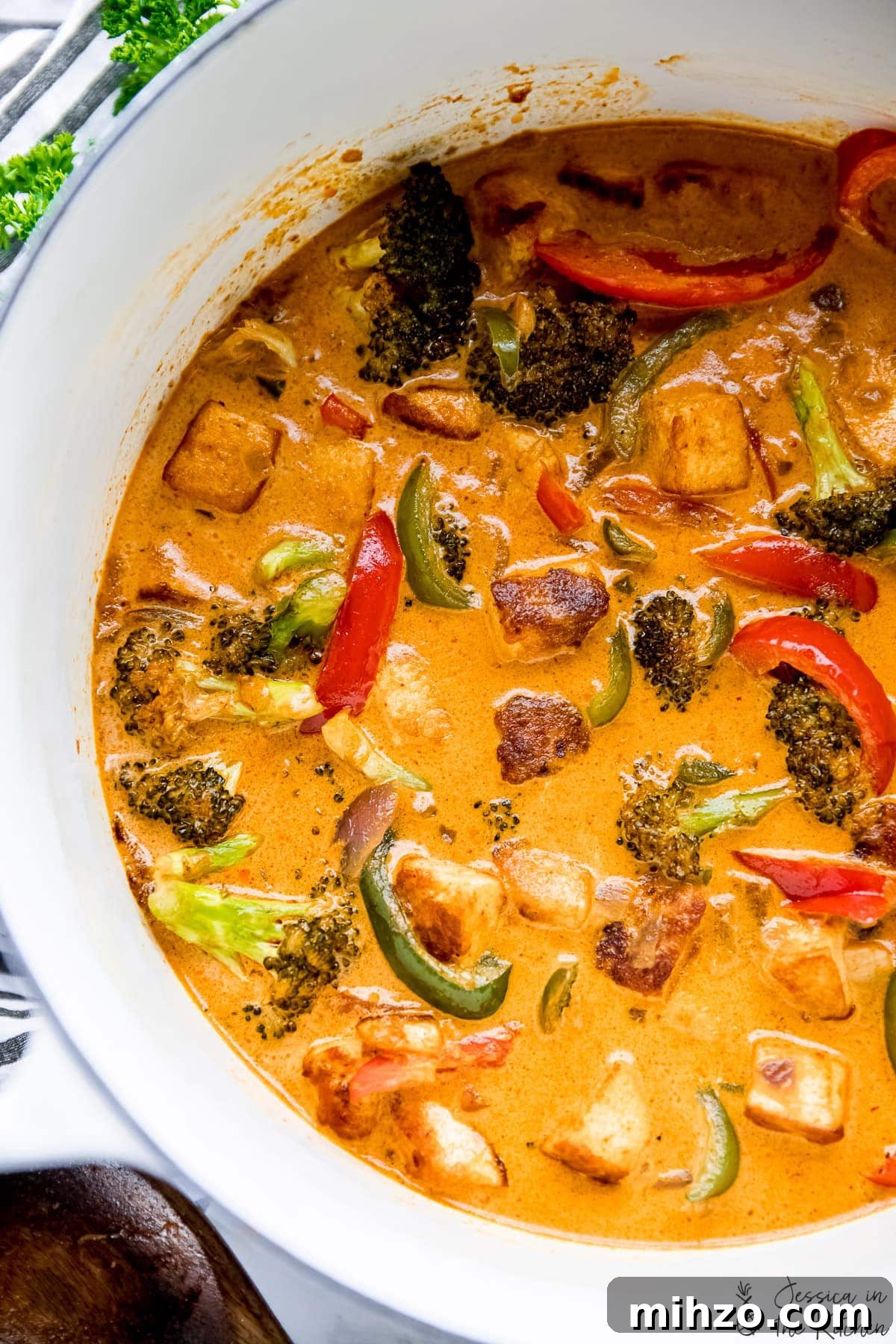 This fragrant Thai red curry is packed with veggies and tender marinated tofu for a satisfying meal. Just add rice or your favorite grain! Overhead view of vegan Thai red curry in white Dutch oven