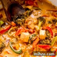 Authentic Thai Red Curry Recipe: Creamy Coconut Chicken Curry 3 Close up shot of vegan thai red curry in a white pot with a spatula in it.
