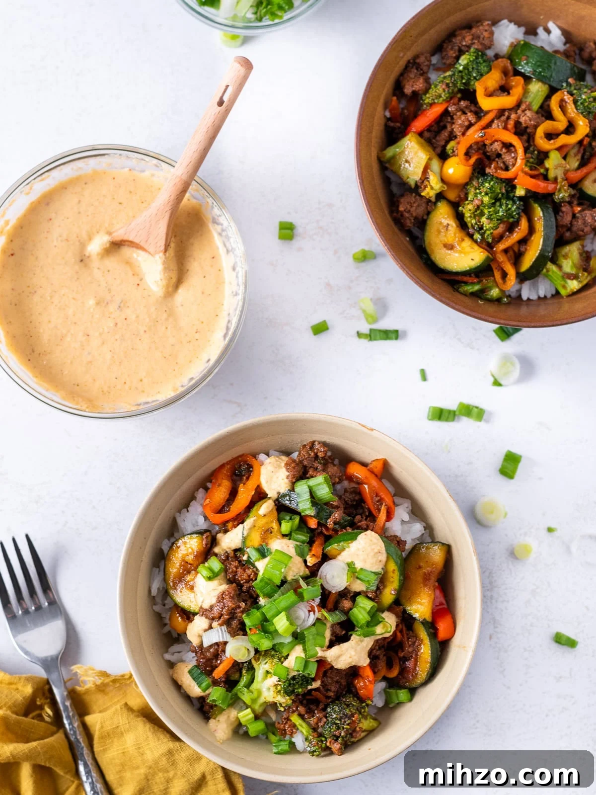 Teriyaki Beef Bowl with Spicy Kimchi Mayo Dressing 12 two bowls of teriyaki beef and vegetables, bowl of kimchi mayo, napkin and fork