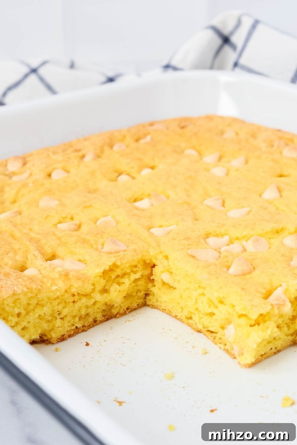 Creamy Lemon Pudding Dump Cake Recipe for Quick Desserts 7 pan of lemon pudding cake bars, with some of the bars removed from the pan, showcasing the moist interior of the cake.