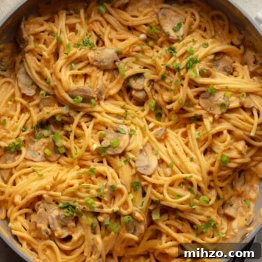 Creamy Gochujang Mushroom Noodles with Sesame and Scallions 9 close up on a skillet full of creamy gochujang noodles.