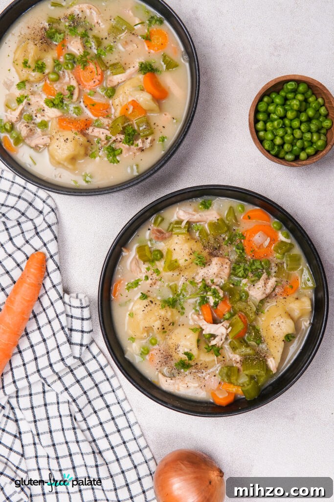 Gluten-Free Soup Dumplings Recipe: How to Make Juicy Xiao Long Bao 15 Top-down view of bowls containing gluten-free dumplings, chicken, celery, carrots, peas, and broth, with parsley sprinkled on top and a bowl of peas on the side.