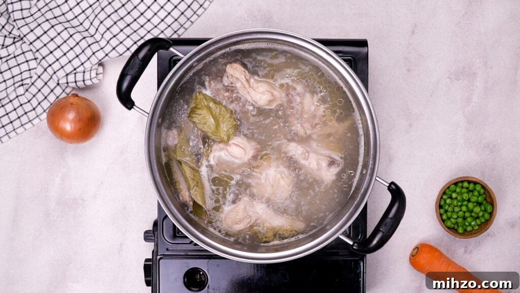 Gluten-Free Soup Dumplings Recipe: How to Make Juicy Xiao Long Bao 8 Chicken simmering in water with bay leaves in the same pot.