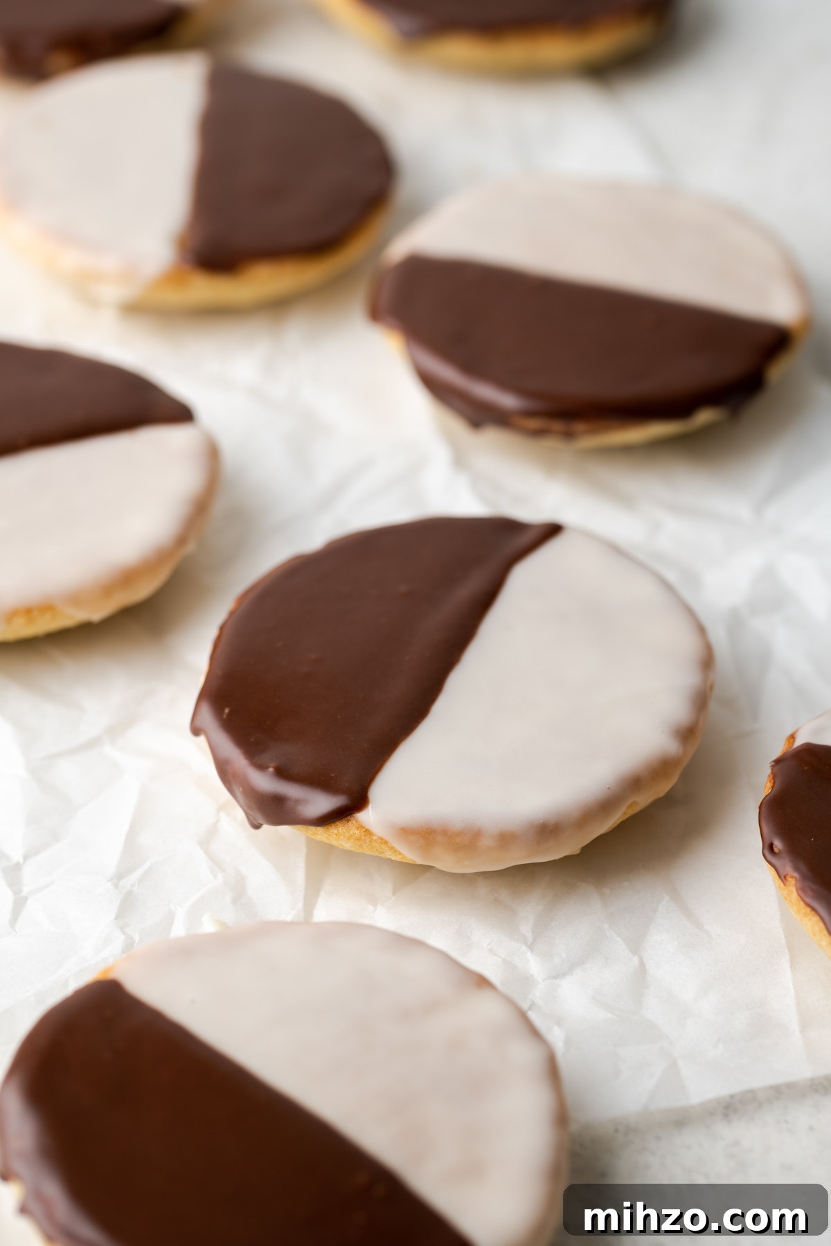 Gluten-Free Black and White Cookies Recipe: Classic New York Treat 2 Gluten free black and white cookies laying on a cookie sheet.