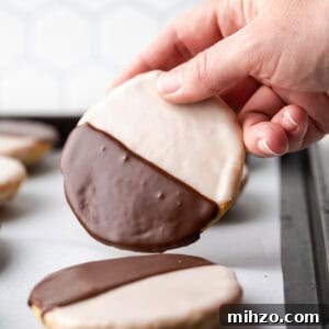Gluten-Free Black and White Cookies Recipe: Classic New York Treat 8 A black and white cookie being picked up from the baking sheet.
