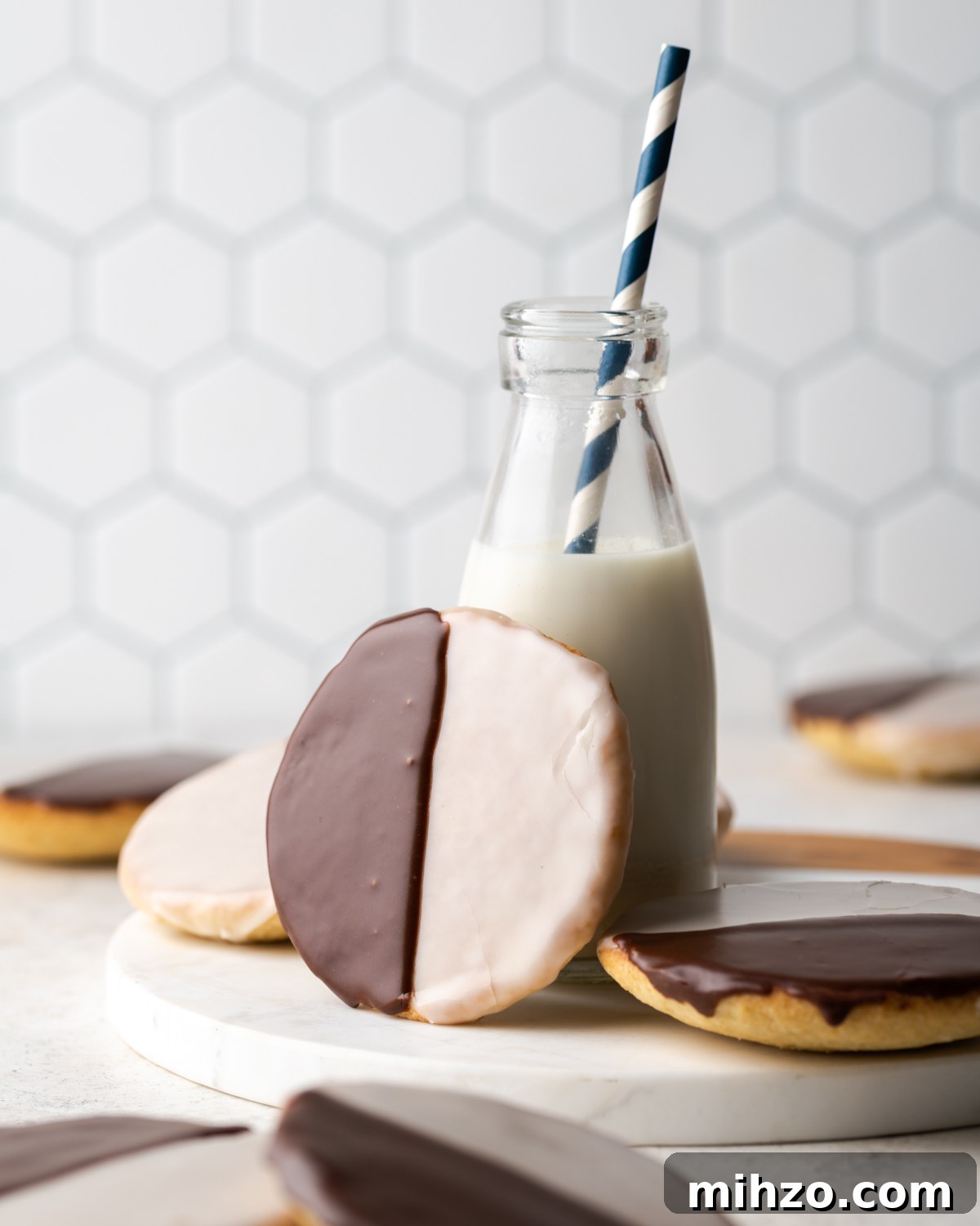 Gluten-Free Black and White Cookies Recipe: Classic New York Treat 3 A black and white cookie propped up against a jar of milk.