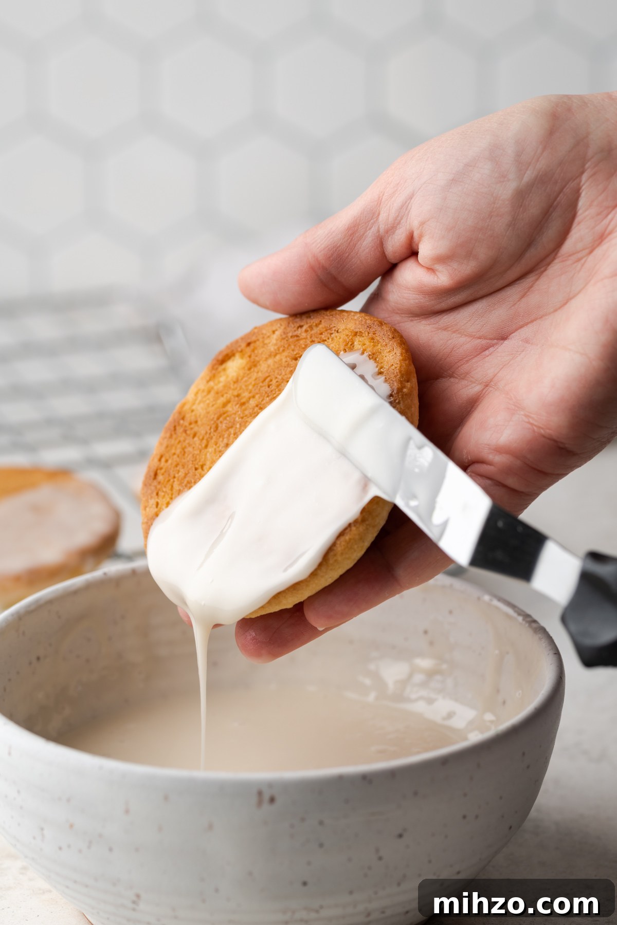 Gluten-Free Black and White Cookies Recipe: Classic New York Treat 5 White fondant icing being applied to half of a black and white cookie.
