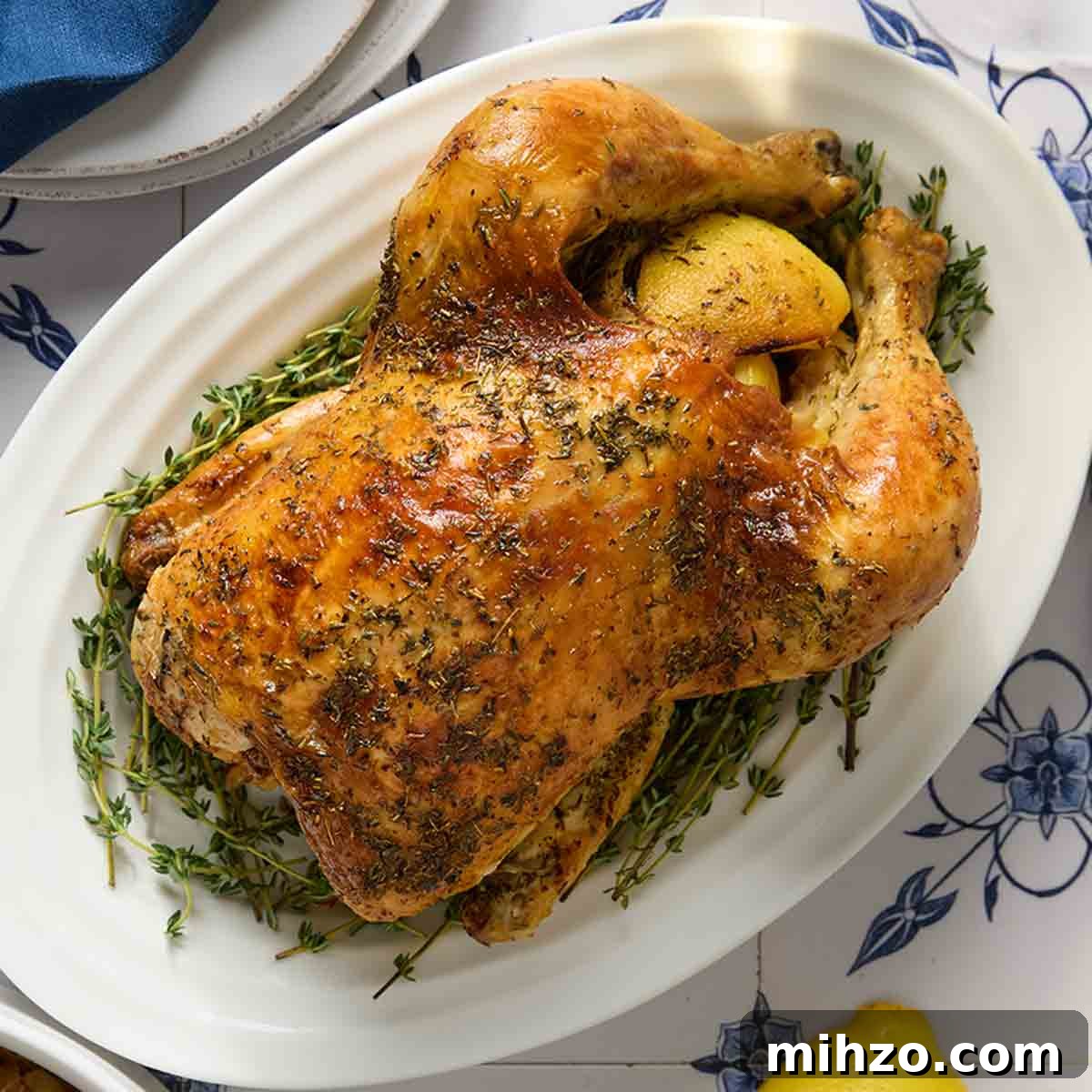 8 Flavorful Whole Roast Chicken Recipes for Every Occasion 11 A whole roast chicken on a platter with a bowl.