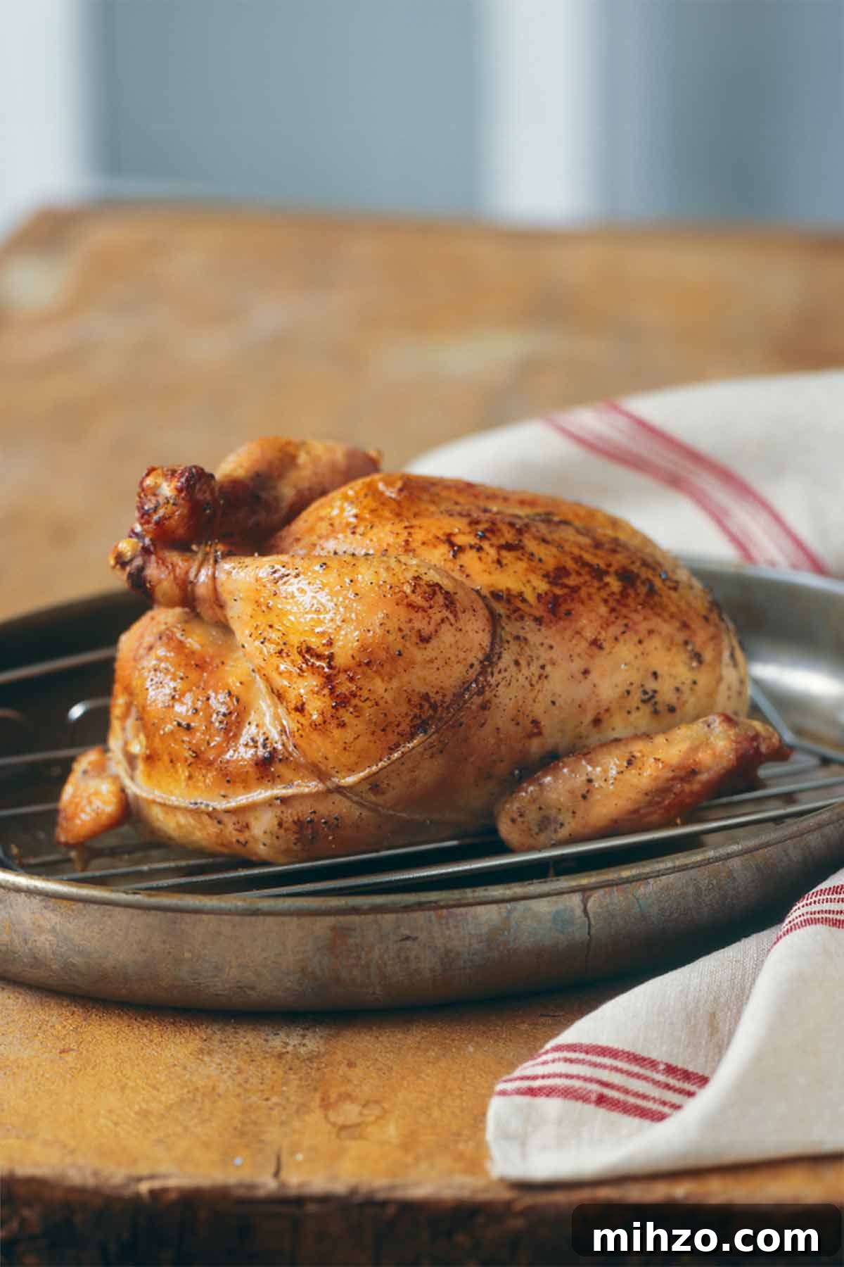 8 Flavorful Whole Roast Chicken Recipes for Every Occasion 4 A trussed classic roast chicken on a rack, set inside a skillet.