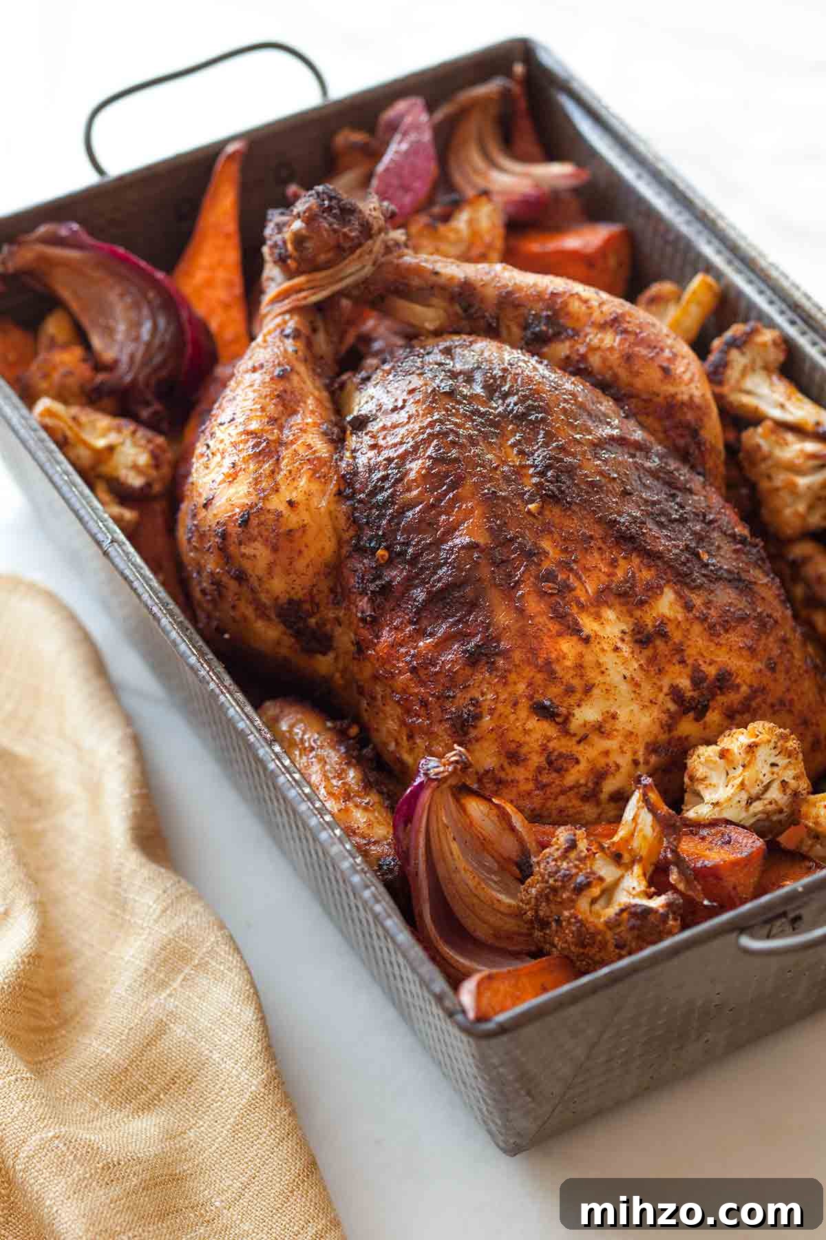 8 Flavorful Whole Roast Chicken Recipes for Every Occasion 7 A deep roasting pan filled with roast chicken and vegetables.