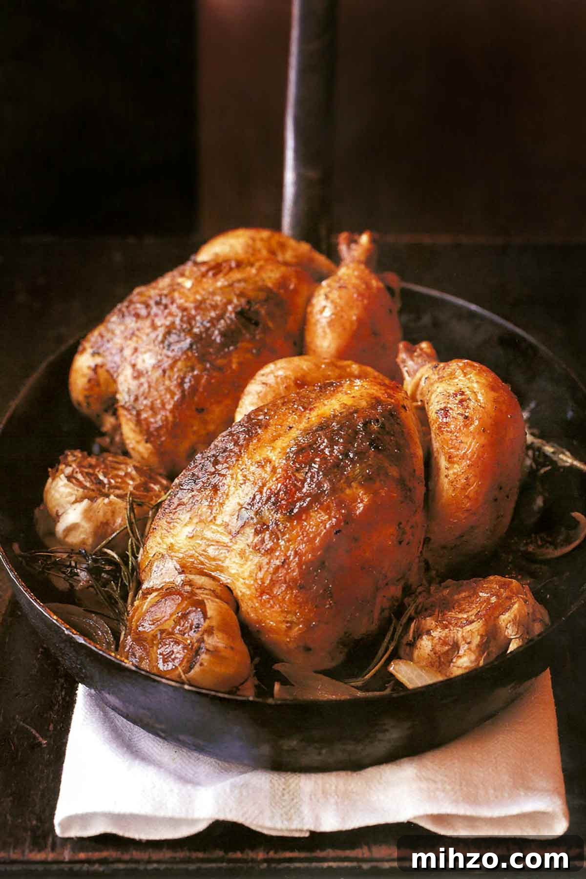8 Flavorful Whole Roast Chicken Recipes for Every Occasion 9 Two whole chickens and whole garlic heads in a cast iron pan.