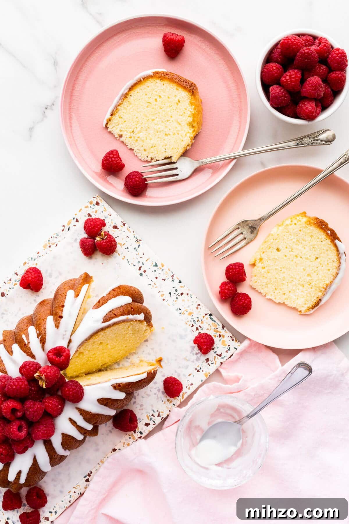 Moist Lemon Loaf Cake Recipe with Zesty Glaze 17 Slices of lemon bread on pink plates, served with raspberries.