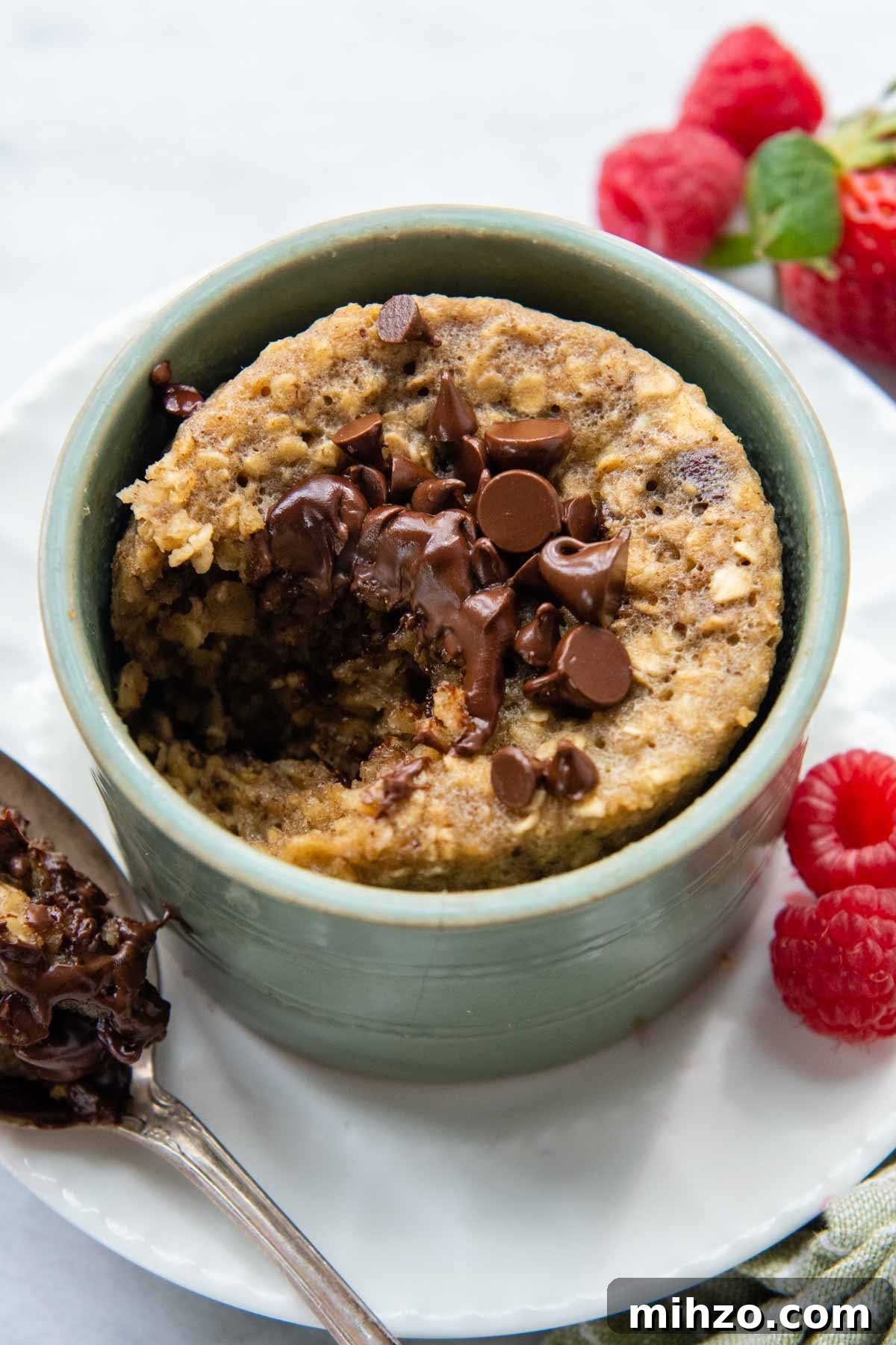 Fluffy 2-Minute Oatmeal Mug Cake — No Flour Mug Cake 2 a bite taken out of the cake with a spoon resting next to it.
