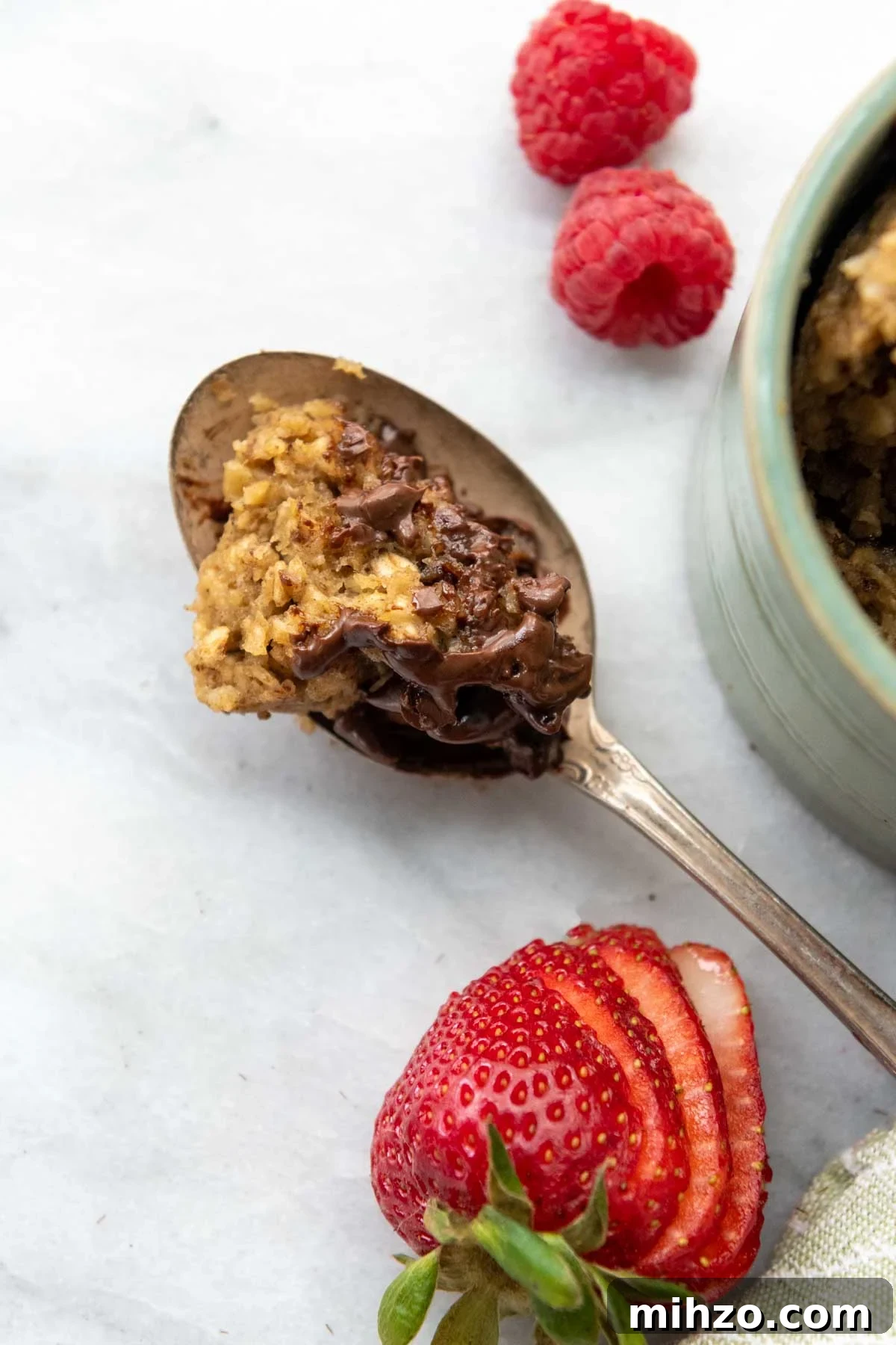 Fluffy 2-Minute Oatmeal Mug Cake — No Flour Mug Cake 5 a spoon of the cake on a white background.