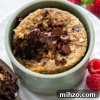 Fluffy 2-Minute Oatmeal Mug Cake — No Flour Mug Cake 7 a bite taken out of the cake with a spoon resting next to it.