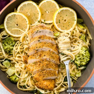 Lemon Garlic Chicken Pasta with Creamy Parmesan Sauce 16 lemon chicken pasta in a pan with fresh lemons, spinach, and broccoli