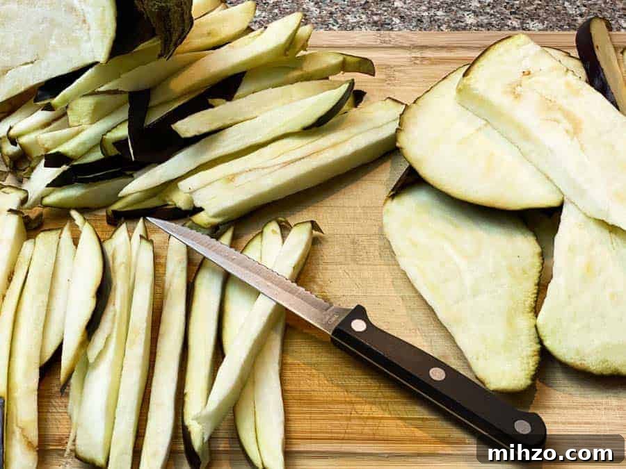 knife on cutting board with sliced eggplant