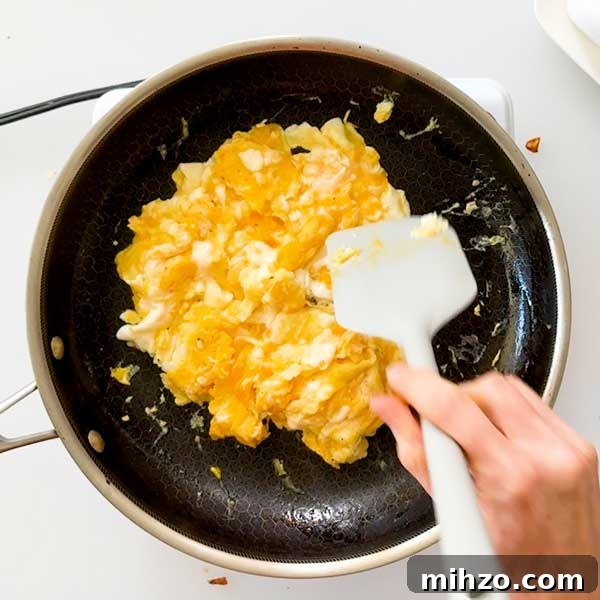 High-Protein Breakfast Burrito with Crispy Potato Filling 8 Scrambling the eggs in a skillet.
