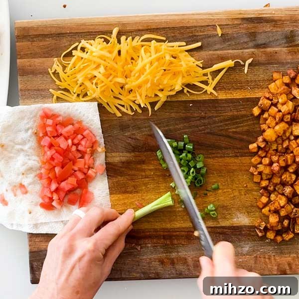 High-Protein Breakfast Burrito with Crispy Potato Filling 9 Dicing the green onion and tomatoes on a cutting board.